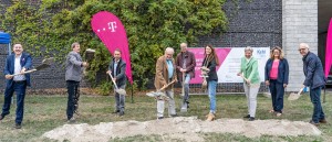 Die Beteiligten werfen beim Spatenstich Erde in die Höhe.