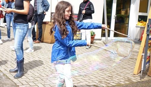 Ein Mädchen formt Riesenseifenblasen.