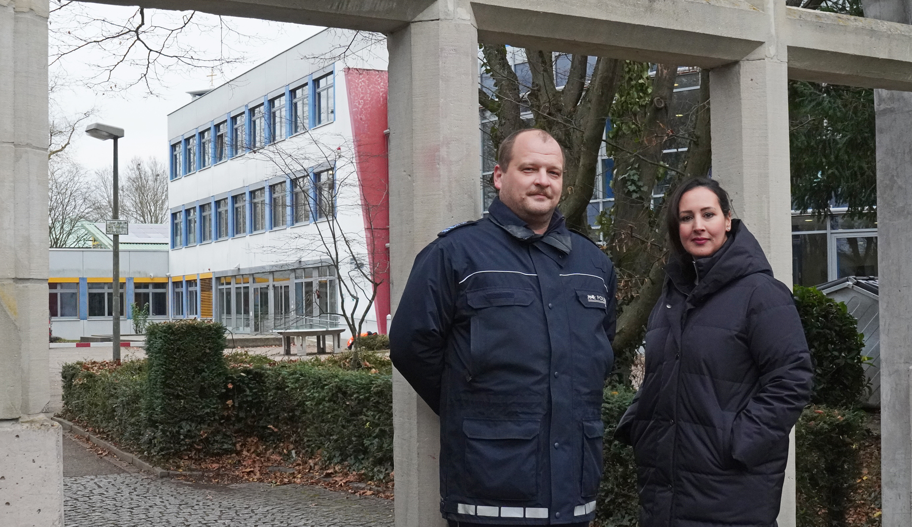 Simon Leinz von der Polizei und Jannate Hammerstein stehen vor dem Einstein-Gymnasium